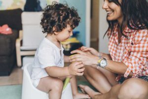 Mother training her toddler to use the potty